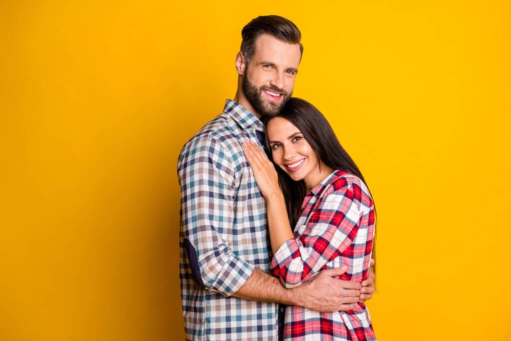Foto portret van gelukkige echtgenoten knuffelen geïsoleerd op levendige geel gekleurde achtergrond met lege ruimte - Foto, afbeelding