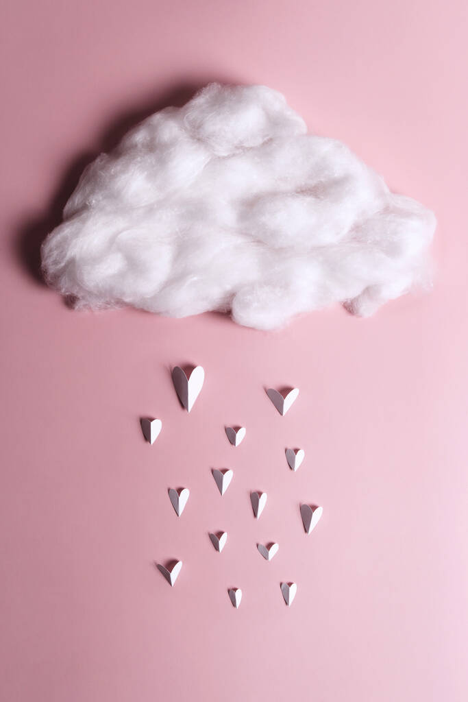 Kreatywne płaskie ułożenie obiektów kształtu serca spadających z chmury na pastelowym tle. Pojęcie miłości - Zdjęcie, obraz