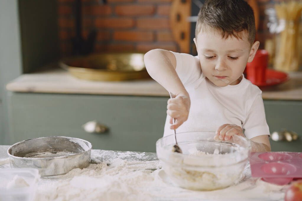 Маленький мальчик готовит тесто для печенья - Фото, изображение