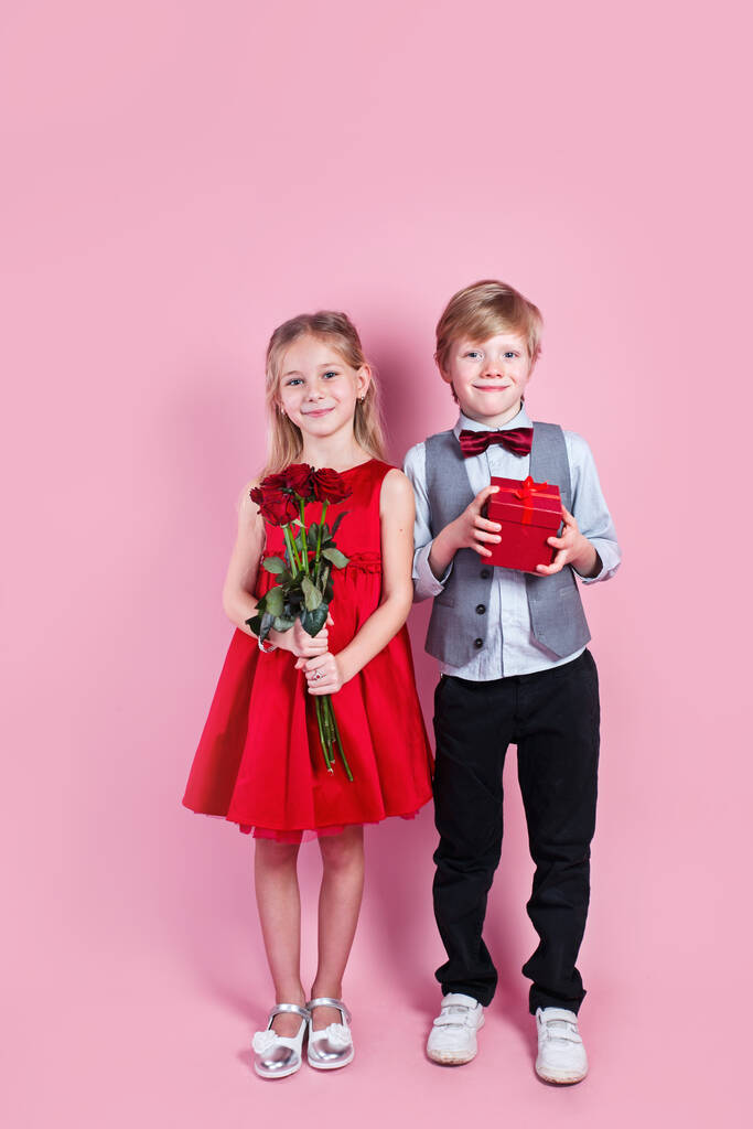 Сюрприз на День Святого Валентина. Маленький влюбленный мальчик дарит милой девушке красную розу, первую любовь - Фото, изображение