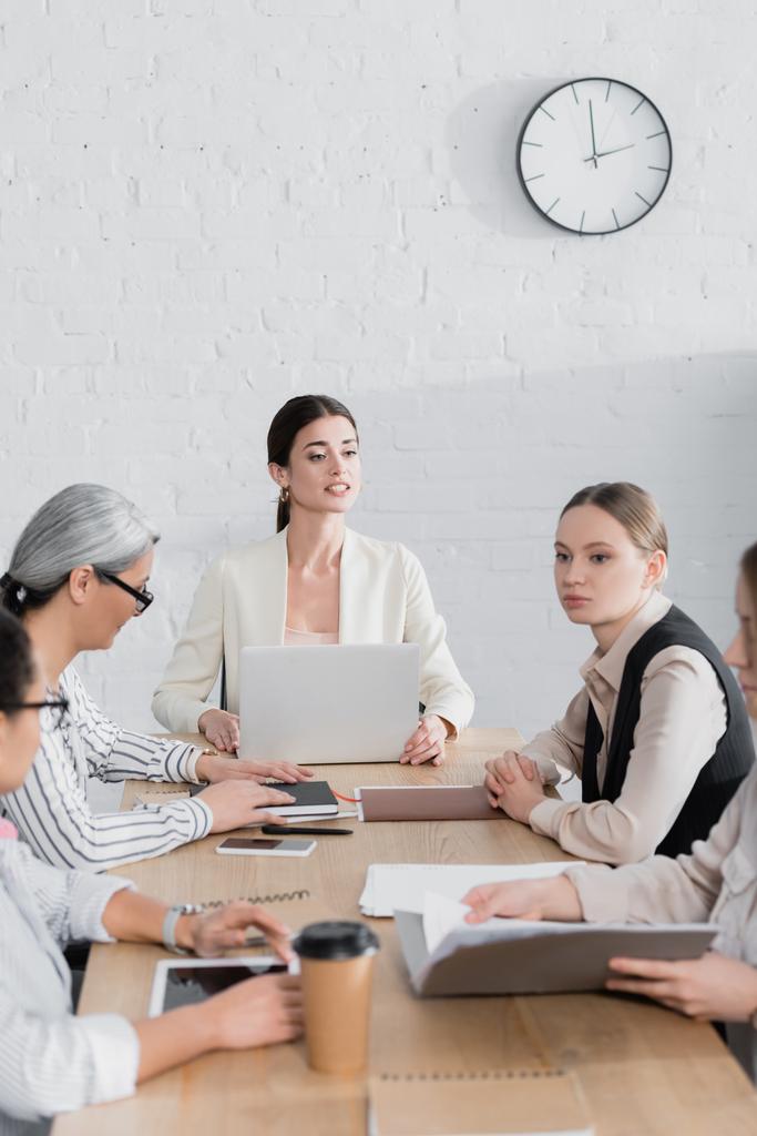 успешный руководитель команды смотрит на деловых женщин вблизи мультикультурных коллег во время встречи - Фото, изображение