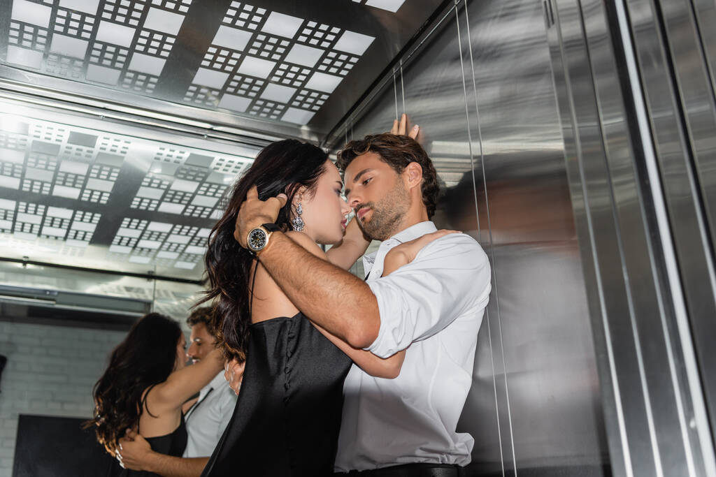 elegancka młoda para obejmująca twarz w windzie - Zdjęcie, obraz