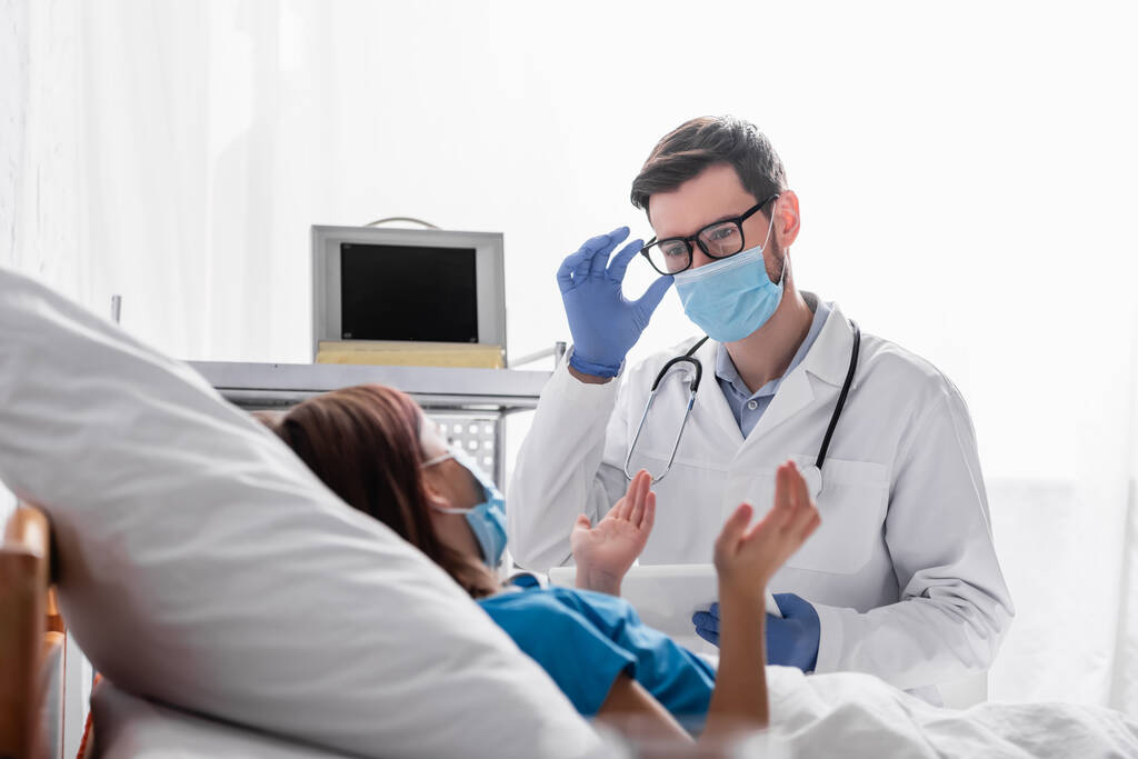 médico em máscara médica fixação óculos perto criança gestos na cama - Foto, Imagem