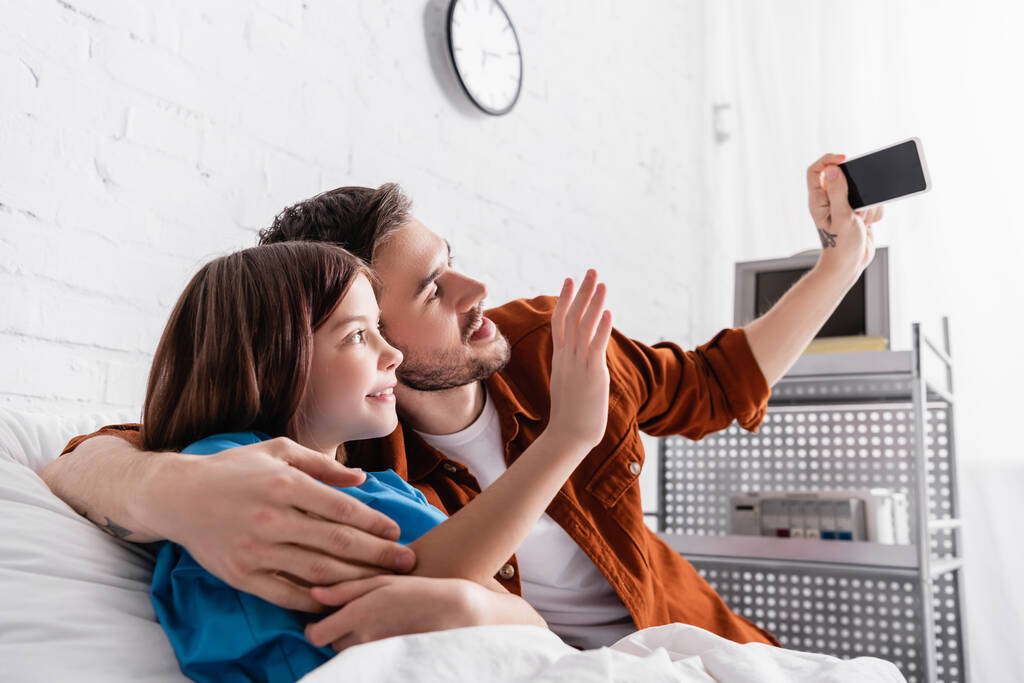 homem alegre tomando selfie no smartphone com a filha no hospital - Foto, Imagem