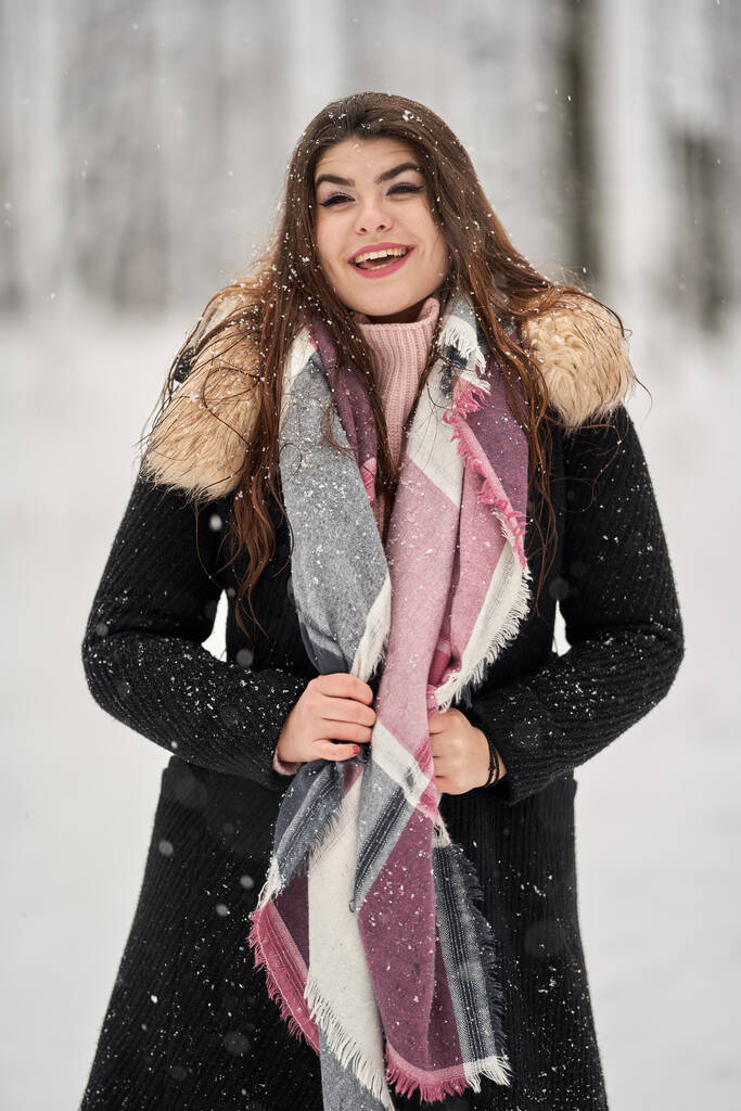 Genç beyaz kadın ormanda karda oynarken eğleniyor. - Fotoğraf, Görsel