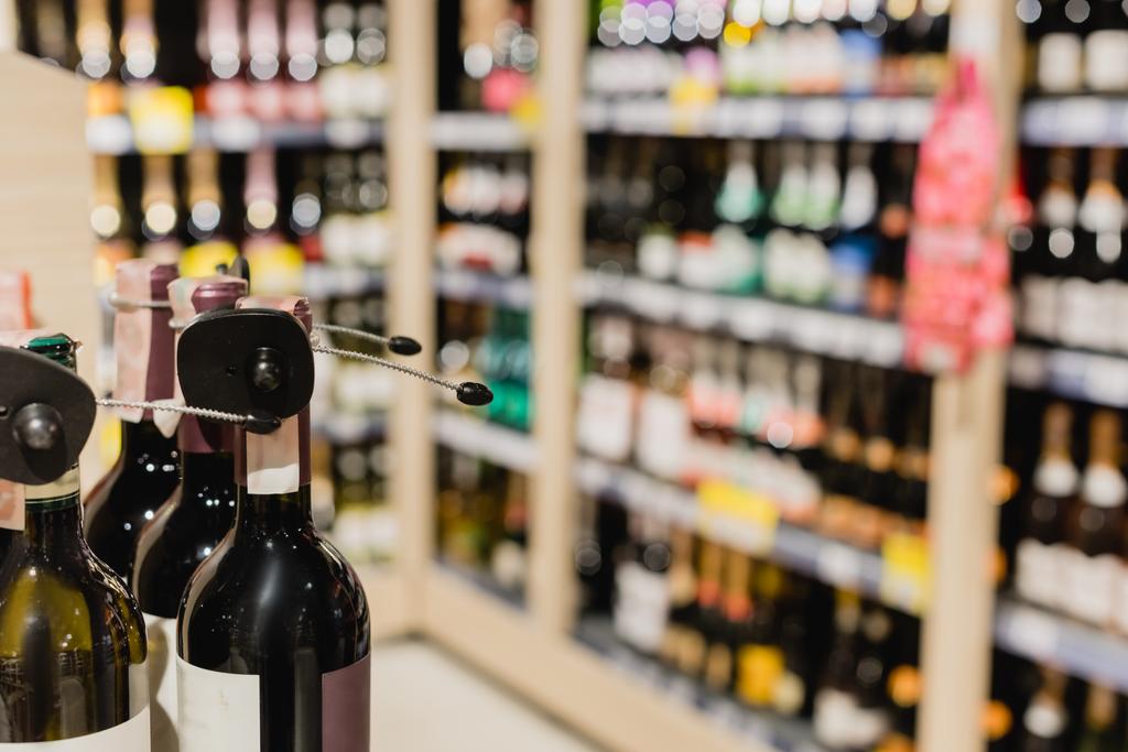 Крупним планом вид пляшок вина в супермаркеті на розмитому фоні
  - Фото, зображення