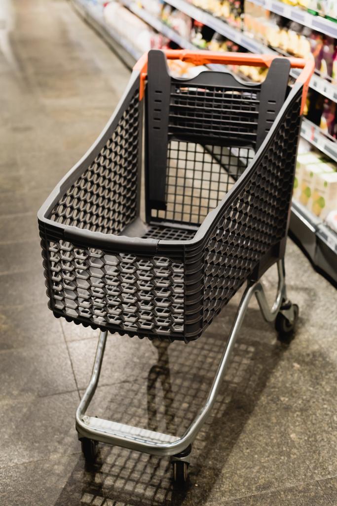 Prázdný nákupní košík v supermarketu na rozmazaném pozadí  - Fotografie, Obrázek