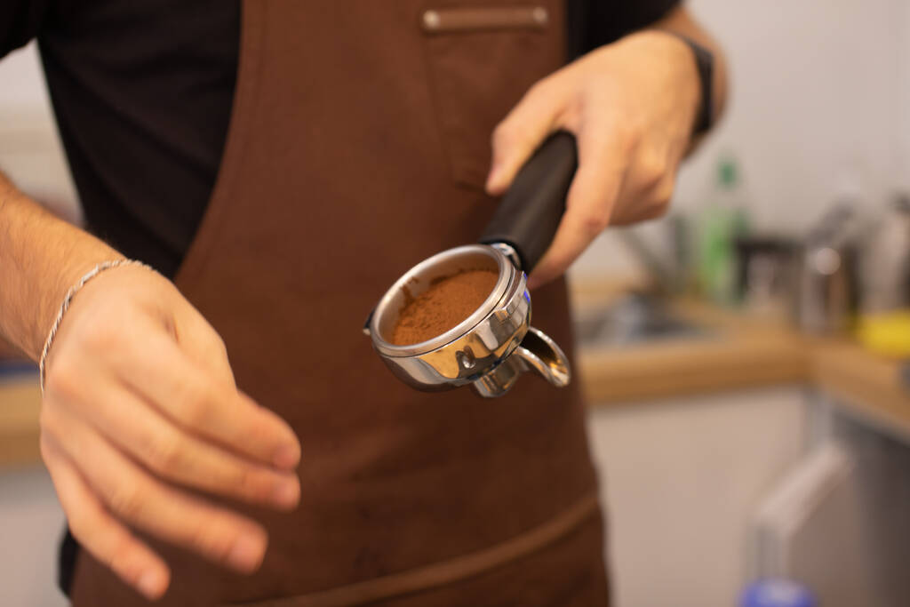 tiro cortado de barista masculino em avental fazendo café em café - Foto, Imagem