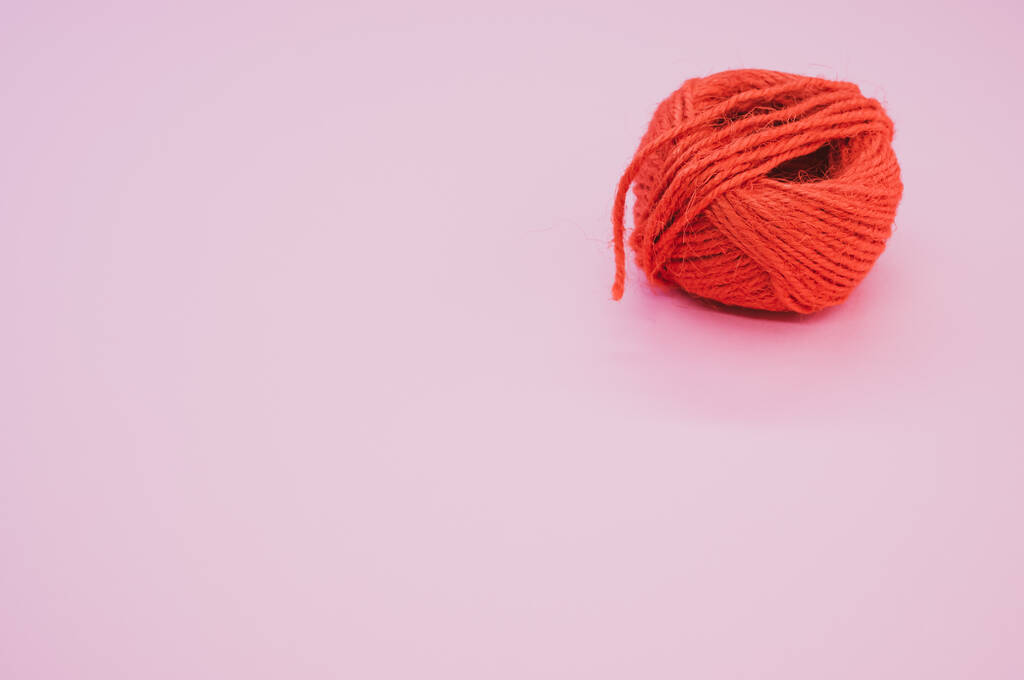 Gros plan d'un fil de laine rouge vif sur fond violet - Photo, image