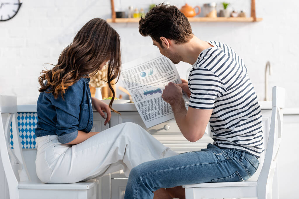 Mann und Frau sitzen auf Stühlen und lesen Zeitung  - Foto, Bild