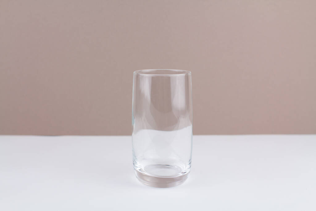 una taza de vidrio sobre fondo marrón blanco con estilo en la cocina - Foto, imagen