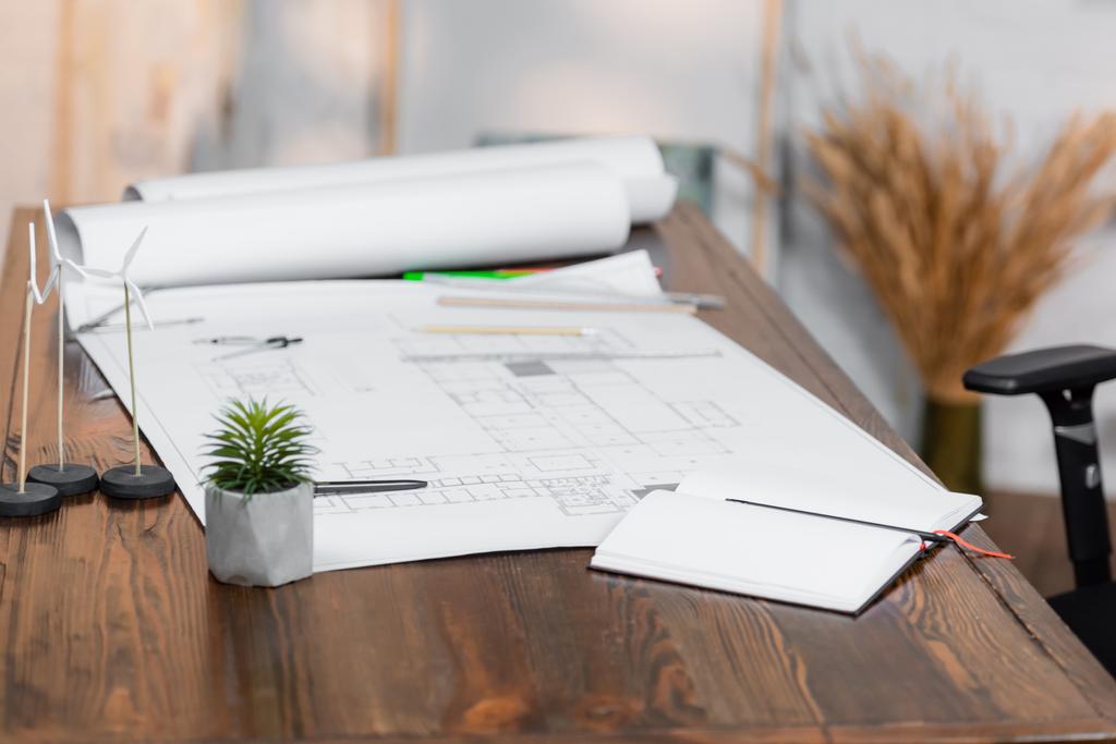 vazio notebook, plantas e modelos de geradores de vento na mesa no escritório, fundo borrado - Foto, Imagem