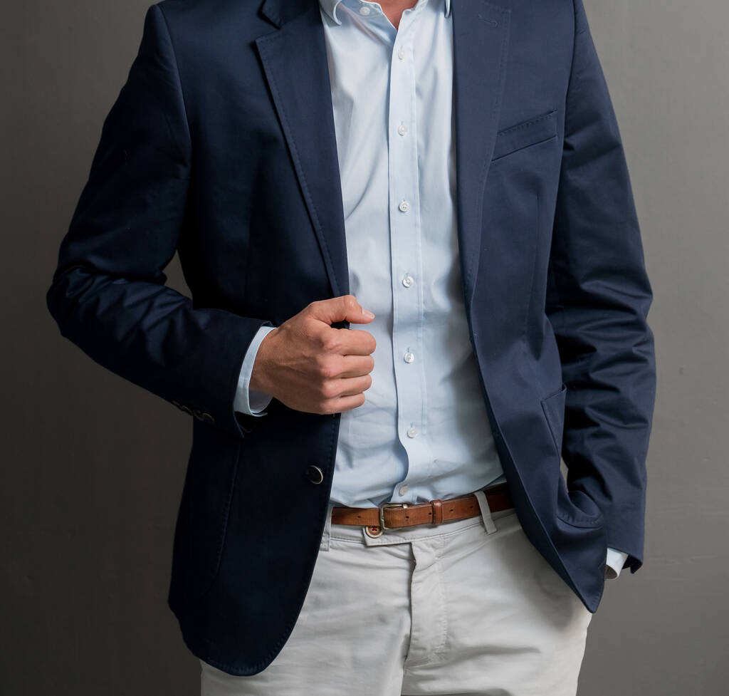 Κοντινό πλάνο ενός άνδρα που φοράει σκούρο μπλε κοστούμι με ανοιχτό μπλε πουκάμισο που στέκεται με το ένα χέρι στην τσέπη - εμφάνιση γραφείου - Φωτογραφία, εικόνα