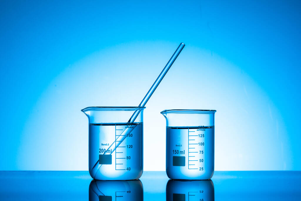 Los dos frascos de vidrio con líquido en una pestaña de laboratorio - Foto, imagen