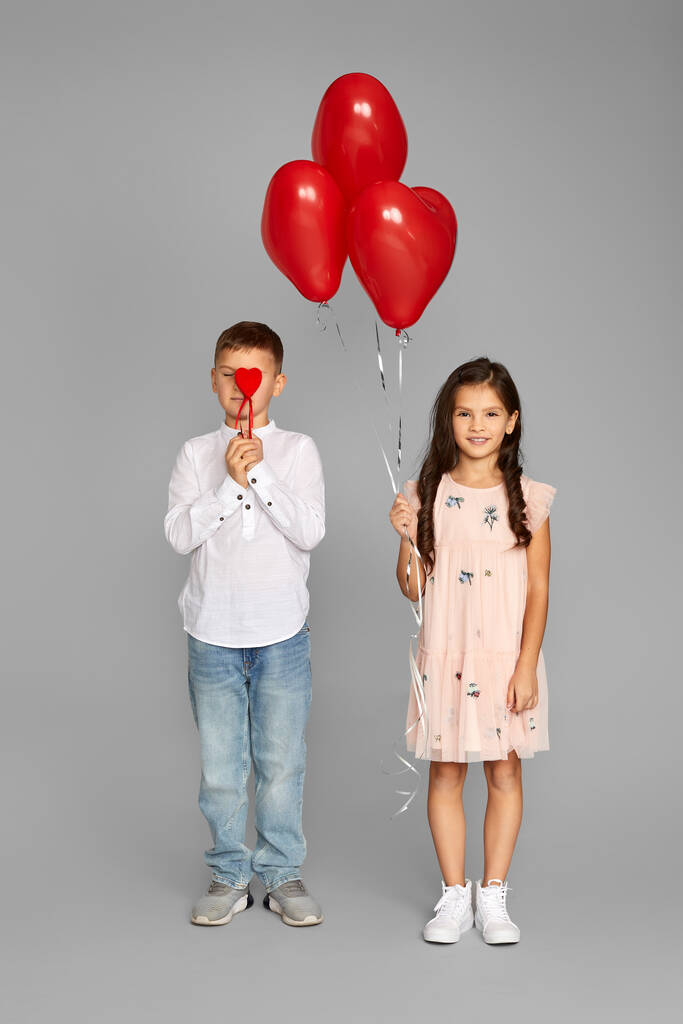 Paar kleiner Mädchen und Jungen mit roten Herzballons - Foto, Bild