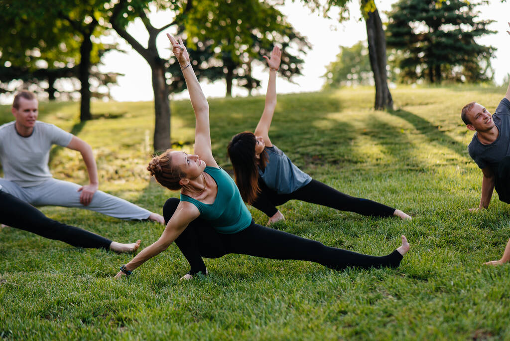 Група людей робить йогу в парку на заході сонця. Здоровий спосіб життя, медитація та оздоровлення
 - Фото, зображення