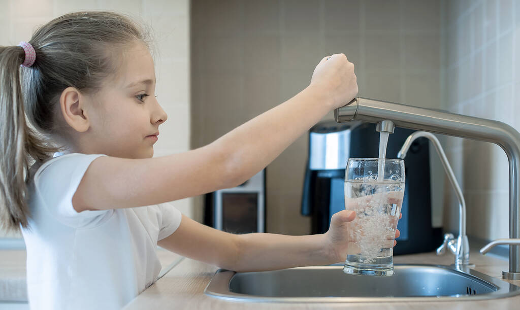 Küçük çocuk açık su musluğu. Mutfak musluğu. Bir bardak temiz su. Taze içki dolduruyorum. Sıvı kaybı. Sağlıklı bir yaşam tarzı. İyi alışkanlık. Su kalitesi kontrolü. Dünya Su İzleme Günü. Plastiksiz konsept - Fotoğraf, Görsel