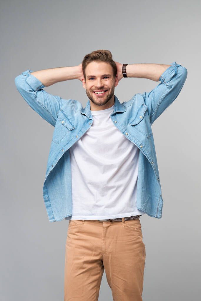 Retrato de joven guapo hombre caucásico en jeans camisa sobre fondo claro - Foto, imagen