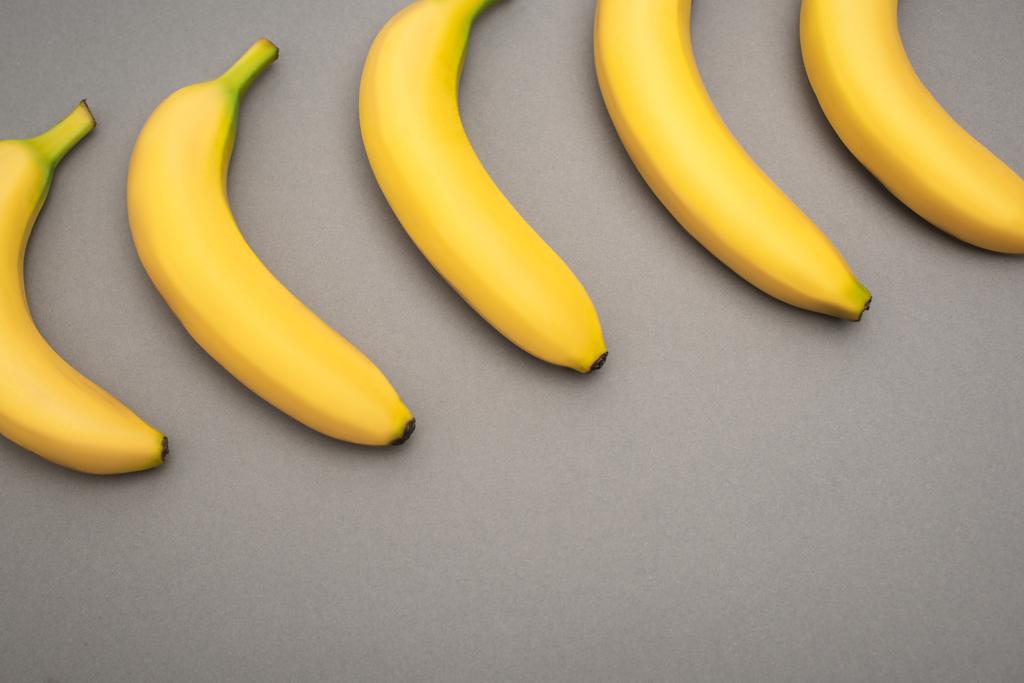 灰色の背景に黄色の熟したバナナの上からの眺め  - 写真・画像