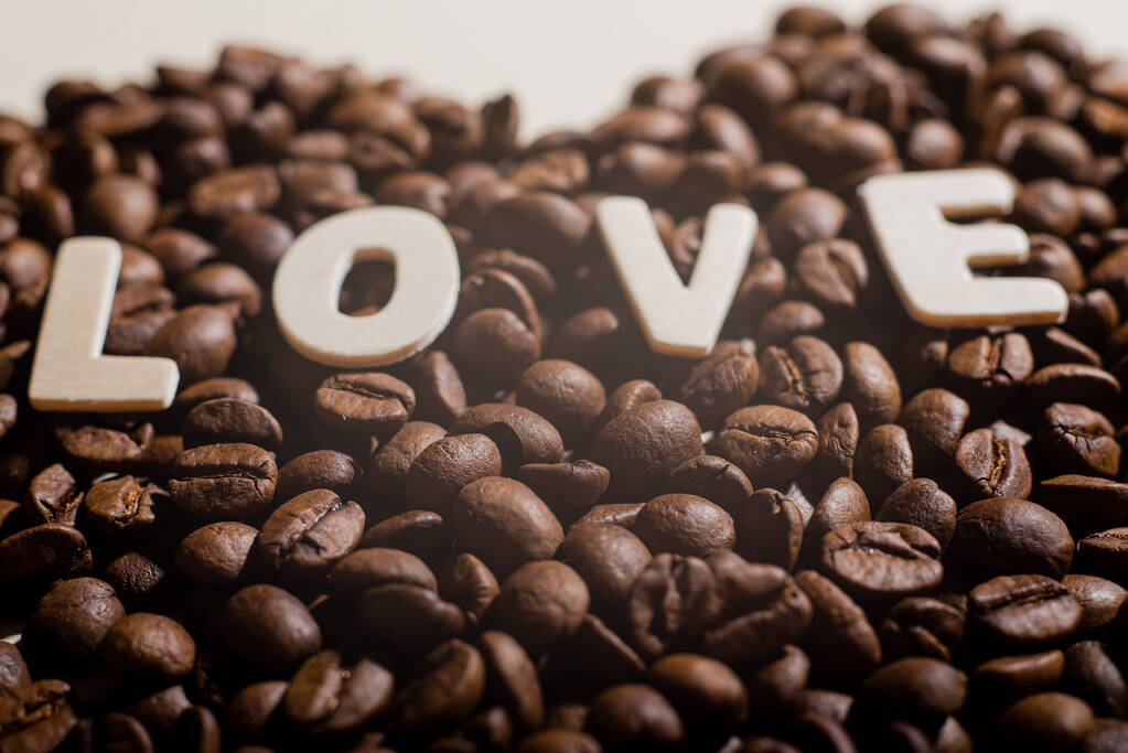 Detailní záběr kávových zrn ve tvaru srdce a nápis láska - Fotografie, Obrázek