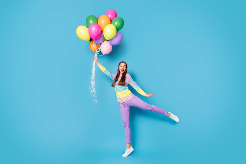 Celá tělo fotografie užaslé dívky držet chytit vzduch létat balónky křičí nosit kalhoty izolované přes modré barvy pozadí - Fotografie, Obrázek