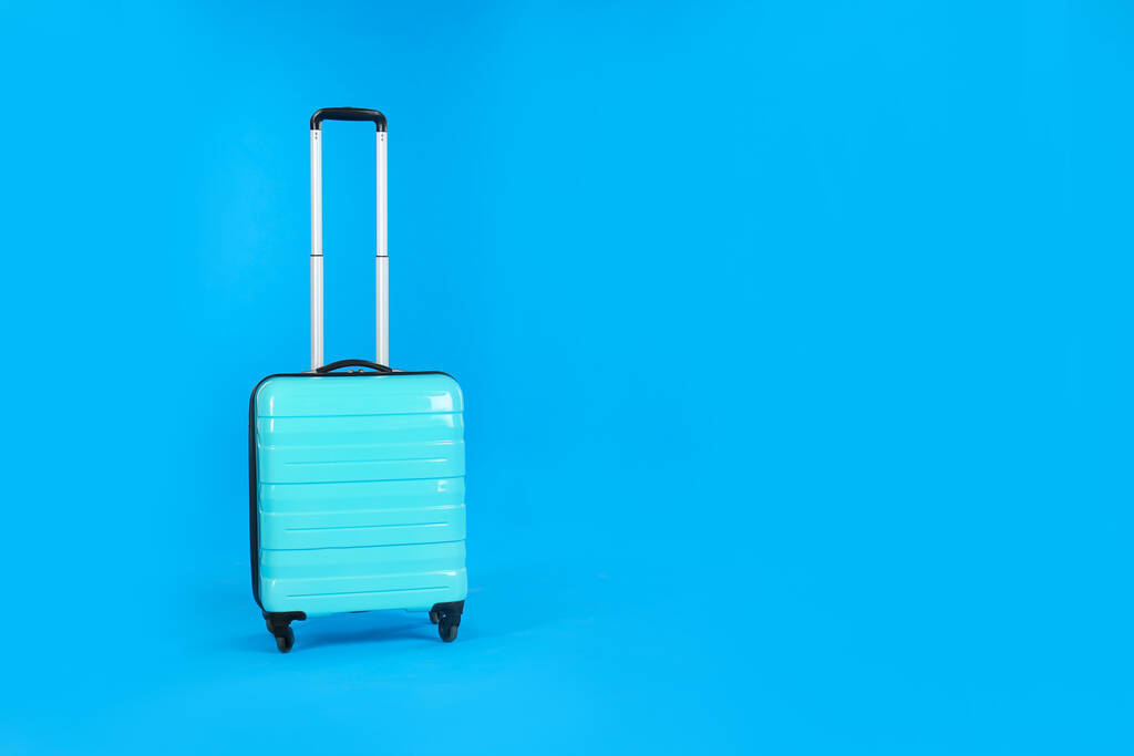 薄い青の背景に旅行スーツケース、テキストのためのスペース。夏休み - 写真・画像