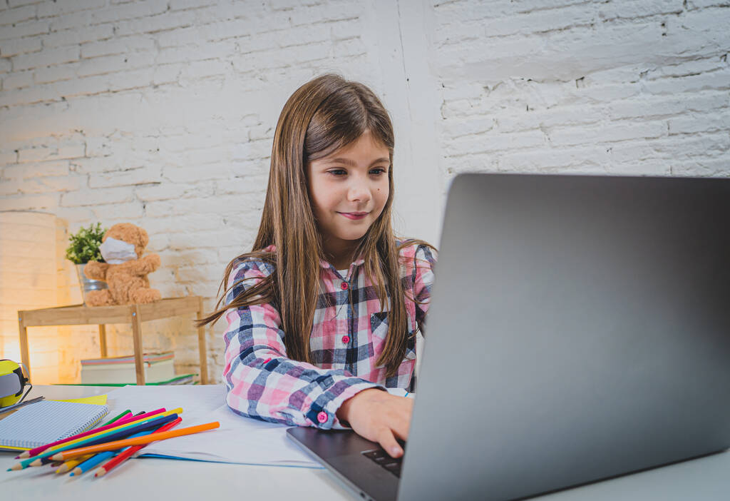 Happy Schoolgirl na laptopie studiuje online w wirtualnej klasie zdalnej w Internecie w domu, jak szkoły pozostają zamknięte ze względu na najnowsze zamknięcie koronawirusów. COVID-19, edukacja, dzieci i e-learning. - Zdjęcie, obraz