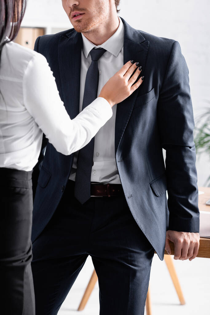 részleges kilátás titkár megható öltöny üzletember, miközben flörtöl vele az irodában - Fotó, kép