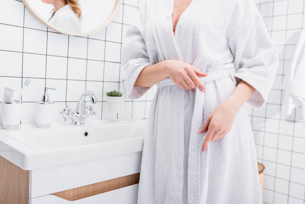 cropped view of woman adjusting white bathrobe  - Photo, Image