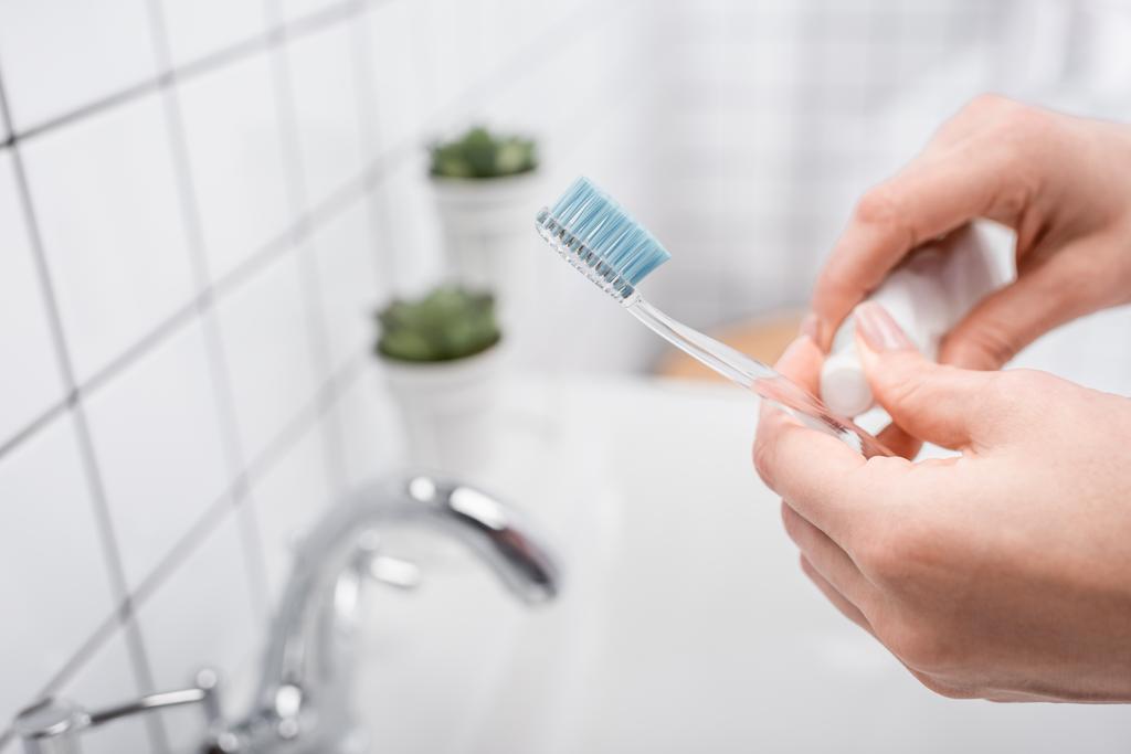 vista recortada de la mujer sosteniendo cepillo de dientes con pasta de dientes  - Foto, imagen