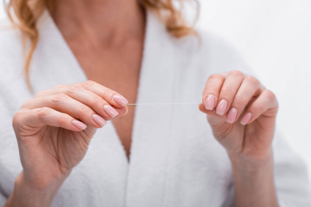 cropped view of woman in bathrobe holding dental floss in bathroom  - Photo, Image