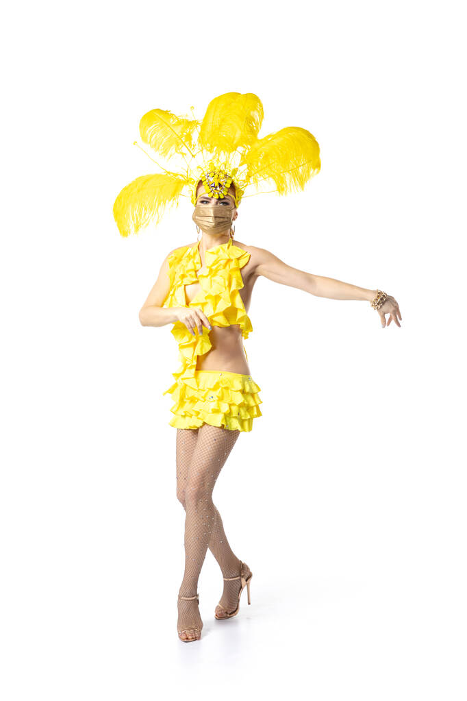 Belle jeune femme en carnaval, costume de mascarade élégant avec des plumes dansant sur fond de studio blanc. - Photo, image
