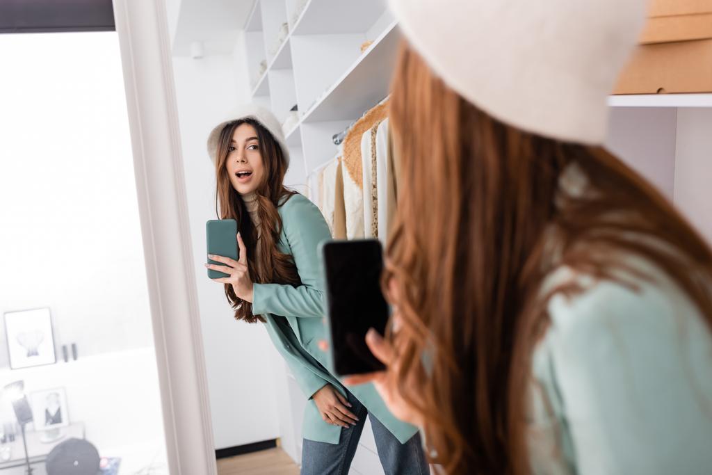 Mulher tirando foto no smartphone enquanto olha para o espelho no guarda-roupa  - Foto, Imagem