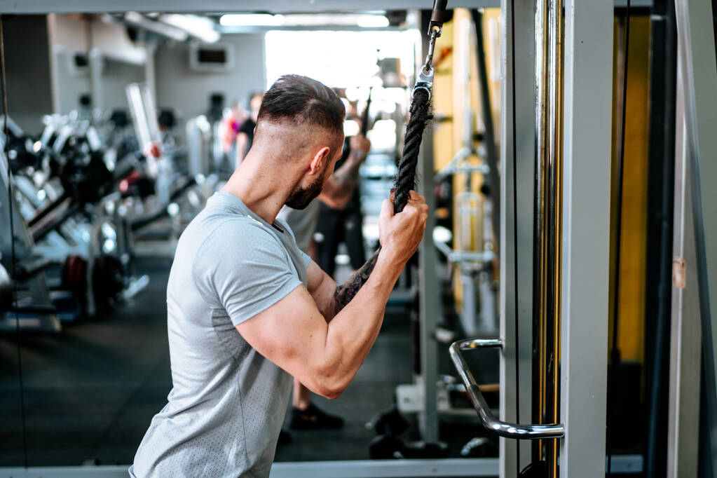 Homem musculoso a treinar bíceps de braços no ginásio. Vida fitness, conceito de vida saudável - Foto, Imagem