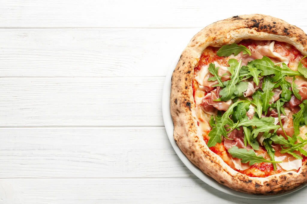 Pizza savoureuse avec viande et roquette sur table en bois blanc, vue sur le dessus. Espace pour le texte - Photo, image