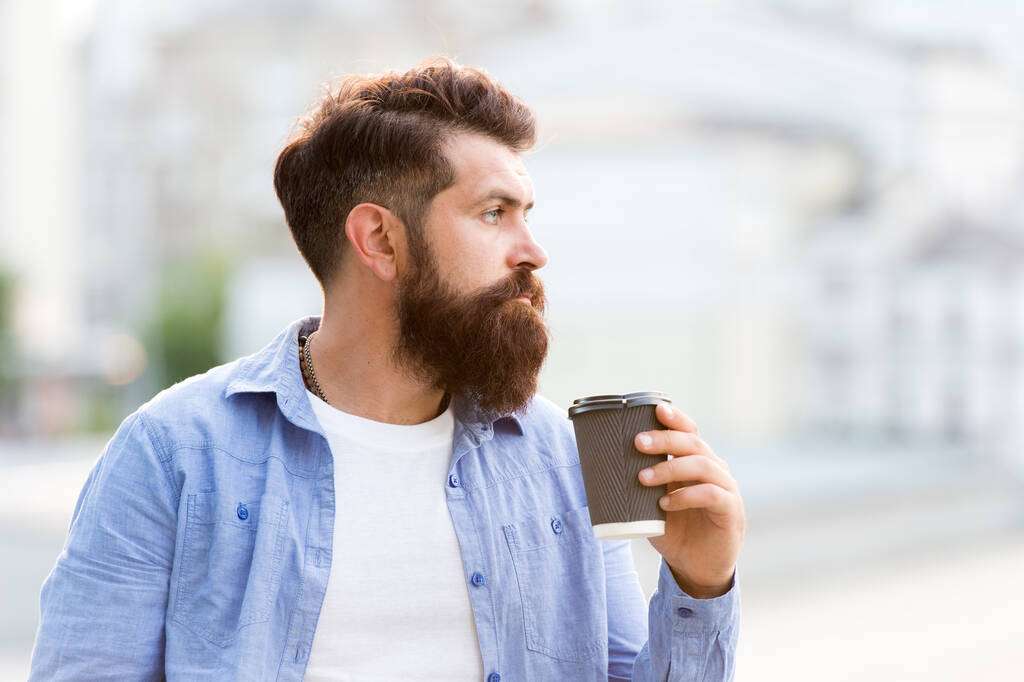 По-перше, вранці. Бородатий чоловік п'є ранкову каву на відкритому повітрі. Хіпстер тримає портативний напій вранці. Сніданок. Його ранкова чашка гарного настрою
 - Фото, зображення