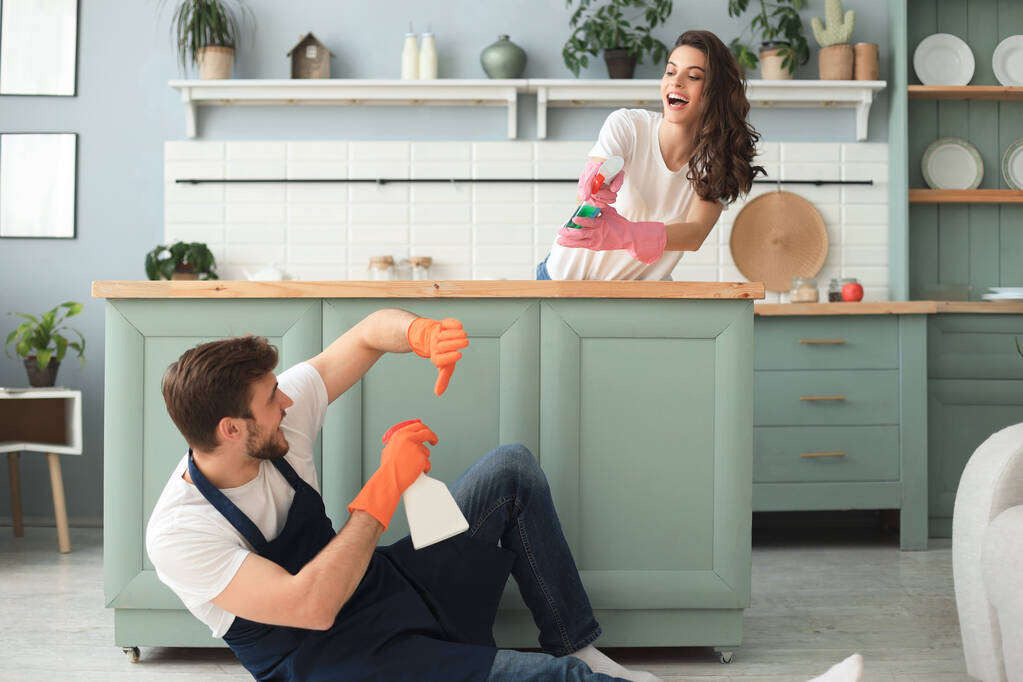 Junges glückliches Paar hat Spaß beim Putzen zu Hause - Foto, Bild
