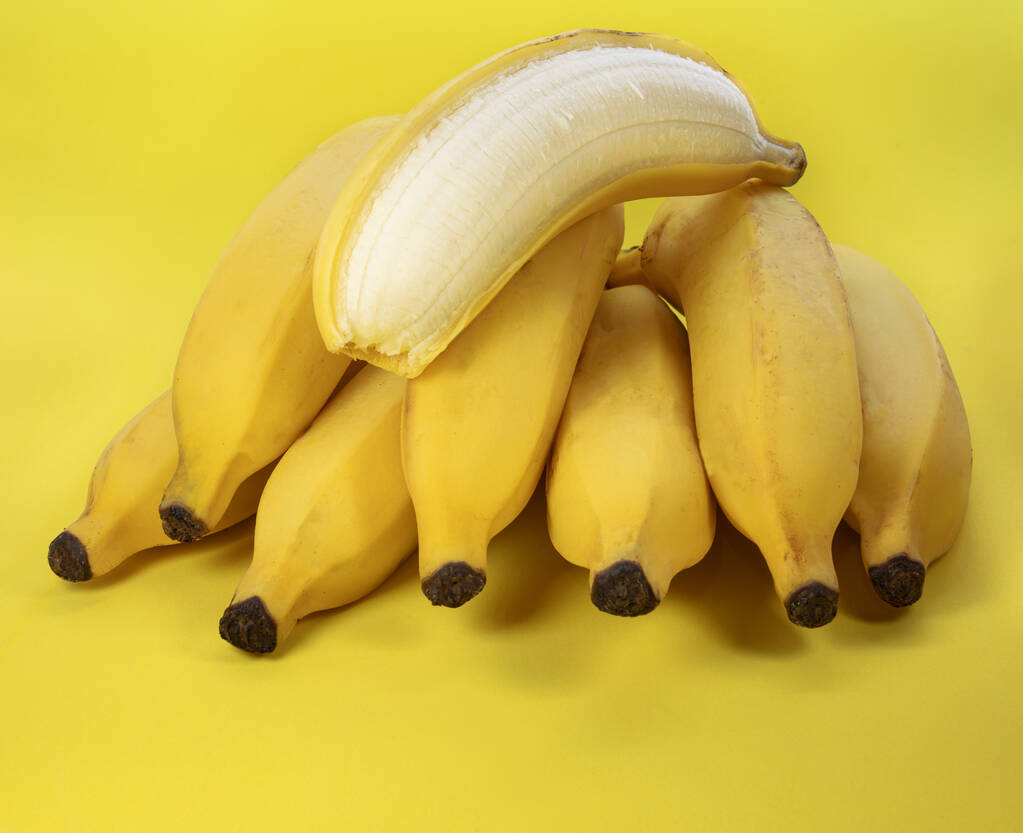 крупним планом знімок частково очищеного банана на пучку бананів
 - Фото, зображення