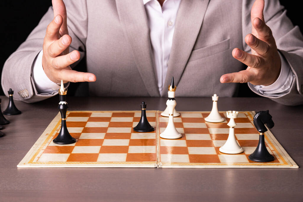Szachownica z człowiekiem myślącym o strategii szachowej - Zdjęcie, obraz