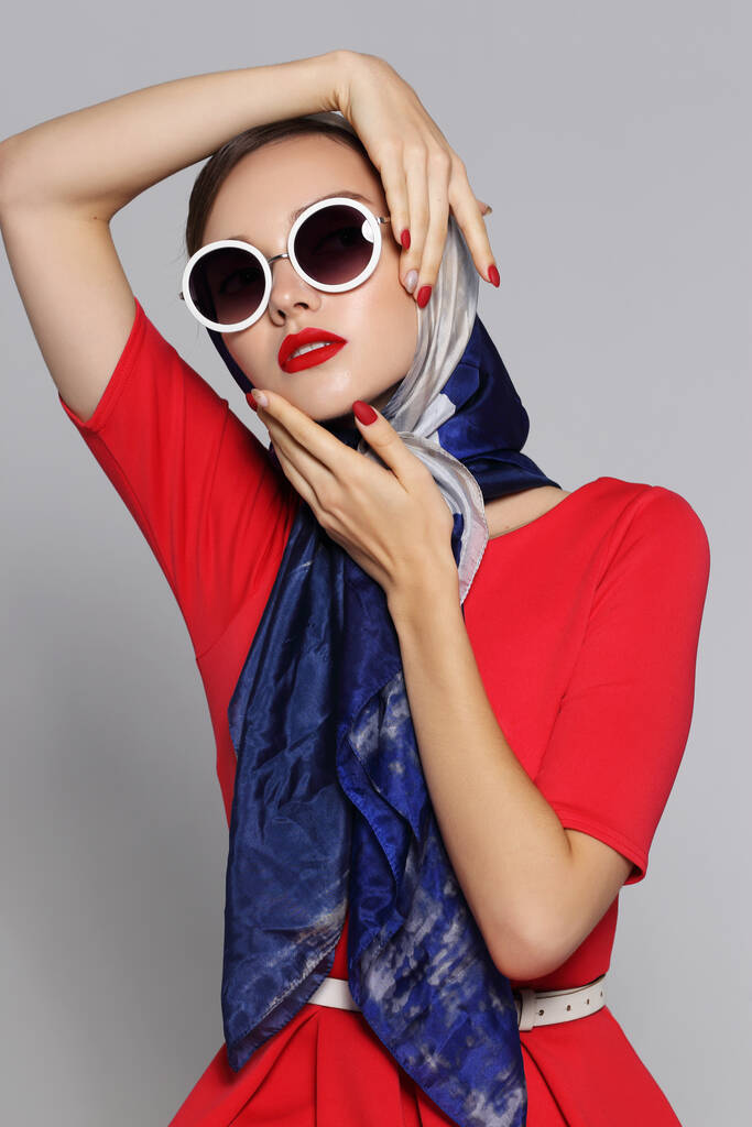 Молодая женщина в стиле ретро. Солнечные очки и шелковый шарф. Ретро-женщина в стиле шестидесятых.  - Фото, изображение