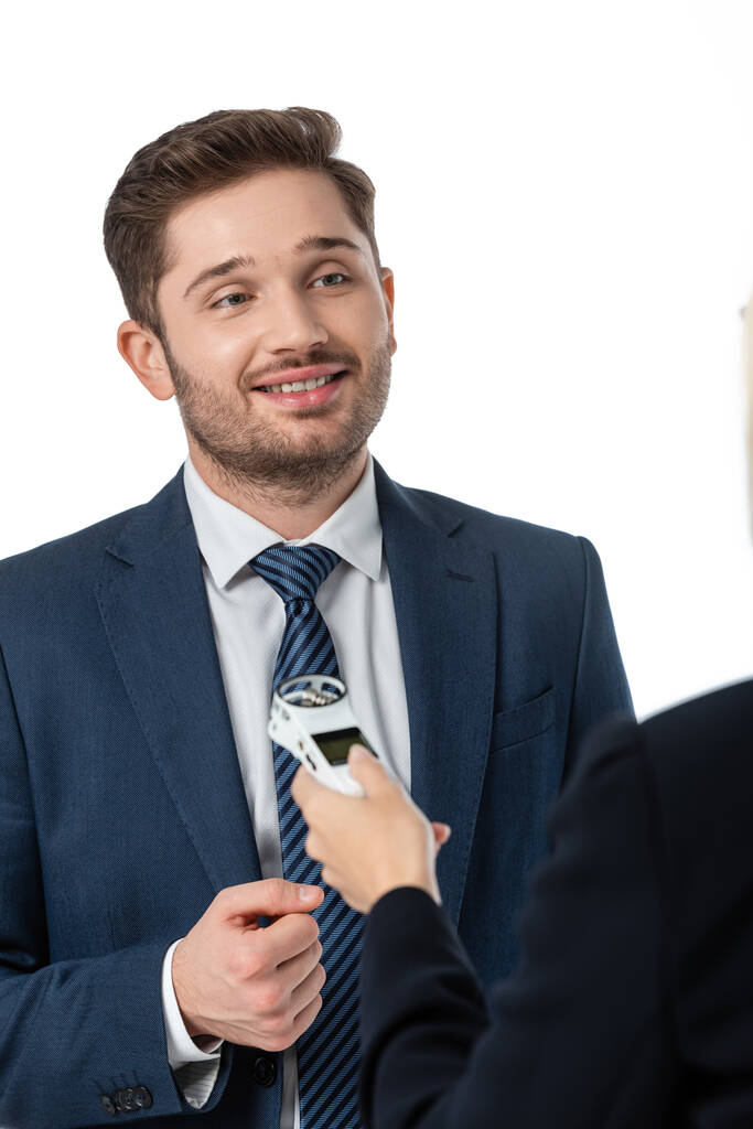 glimlachende zakenman geven interview aan journalist met dictafoon geïsoleerd op wit, wazig voorgrond - Foto, afbeelding