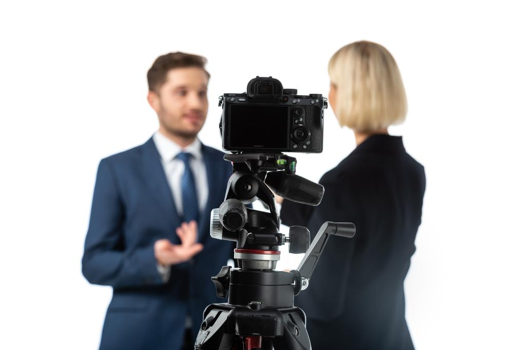 foco seletivo de câmera digital profissional perto de apresentadores de notícias trabalhando em fundo borrado isolado em branco - Foto, Imagem