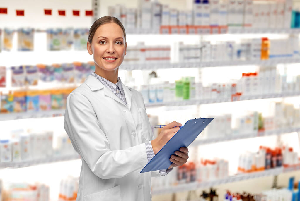 smiling female doctor with clipboard at pharmacy - Photo, Image