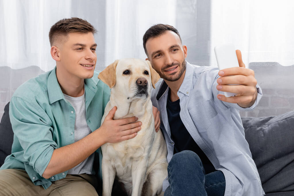 veselý stejný sex pár usměvavý a užívat selfie s labrador - Fotografie, Obrázek