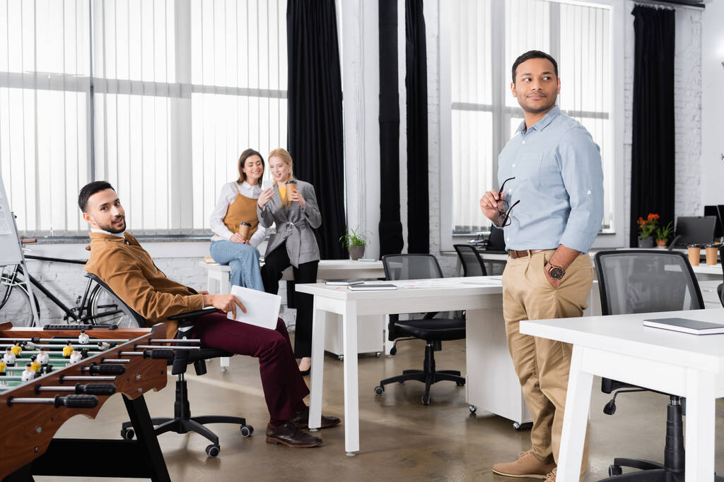 Empresários multiétnicos de pé perto do futebol de mesa no escritório  - Foto, Imagem