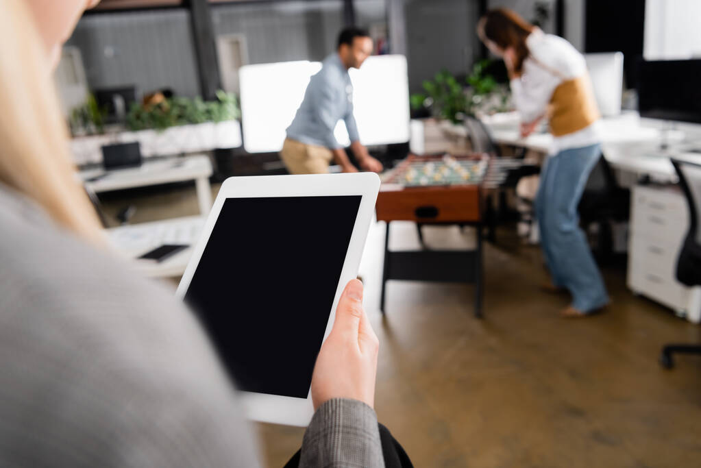 Digitales Tablet mit leerem Bildschirm in der Hand einer Geschäftsfrau auf verschwommenem Vordergrund im Büro  - Foto, Bild