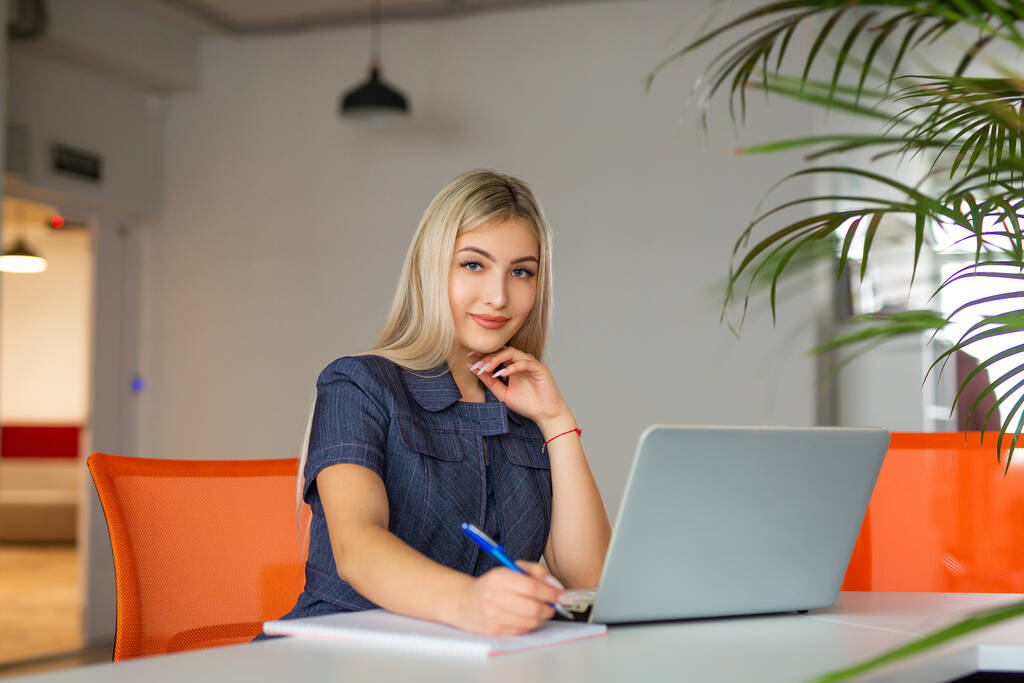 kaunis nuori nainen pöydässä kannettavan tietokoneen toimistossa - Valokuva, kuva