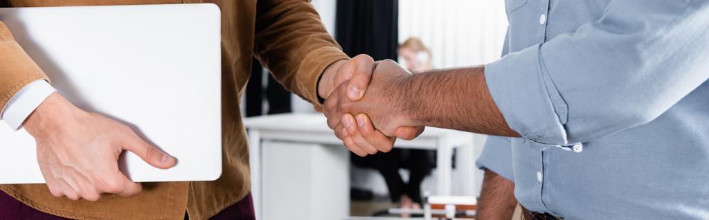 Vista cortada de empresários com laptop handshaking no escritório, banner  - Foto, Imagem