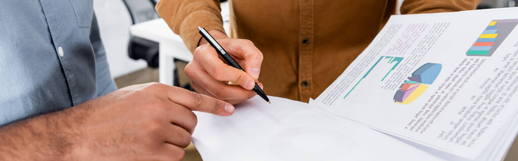 Vista cortada de empresário apontando com o dedo perto colega com papéis e caneta no escritório, banner  - Foto, Imagem