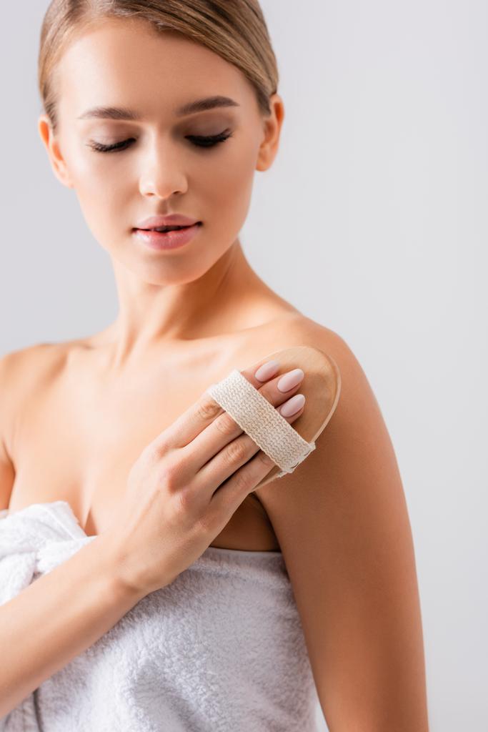 junge Frau Peeling der Haut mit Pinsel isoliert auf weiß - Foto, Bild